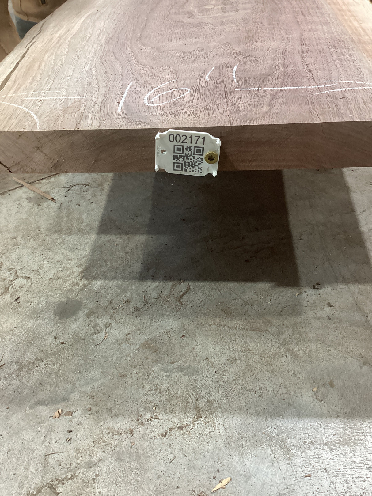 A walnut wood slab with a QR code tag attached to it, displaying potential design uses.