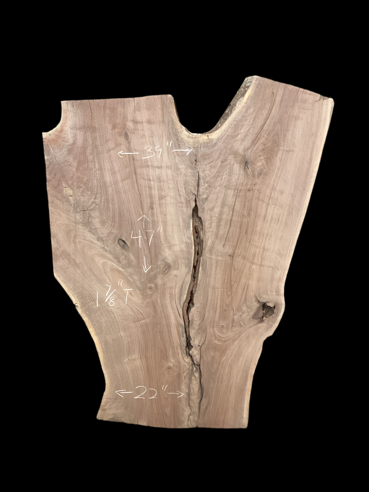 An irregularly shaped walnut slab with a distinctive striped figure pattern on a black background.