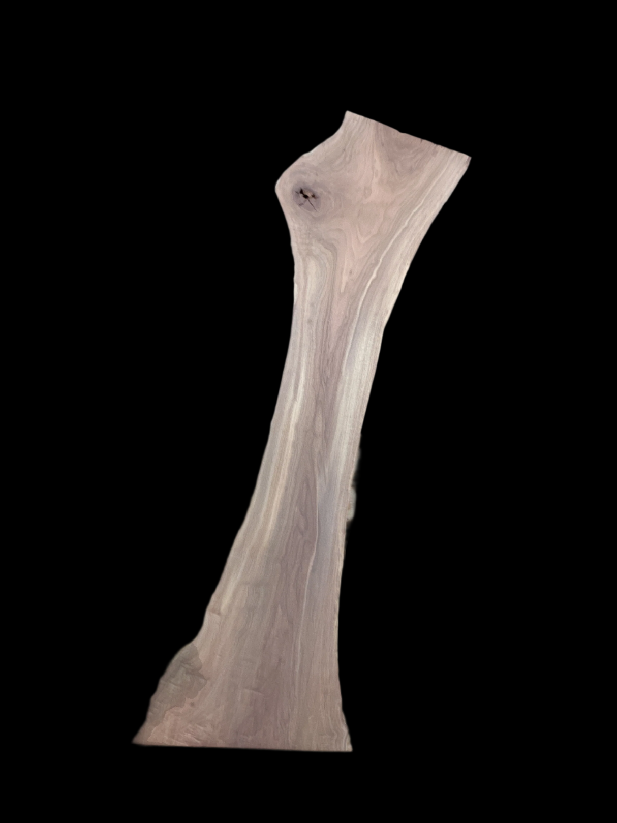 A long thick walnut slab with a black background.