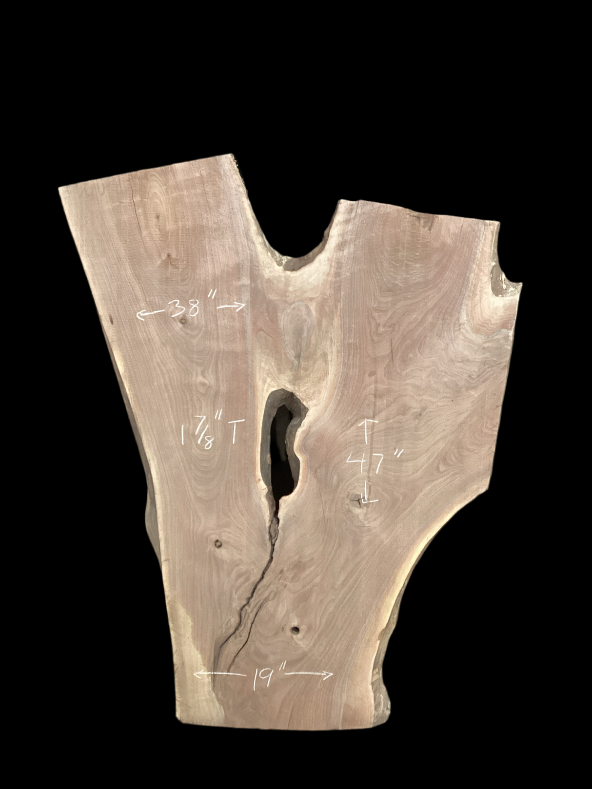 An irregularly shaped walnut slab with a distinctive striped figure pattern on a black background.