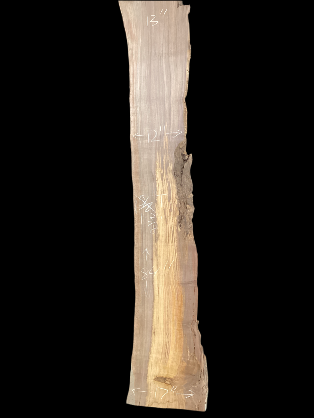 A long walnut slab with a black background.