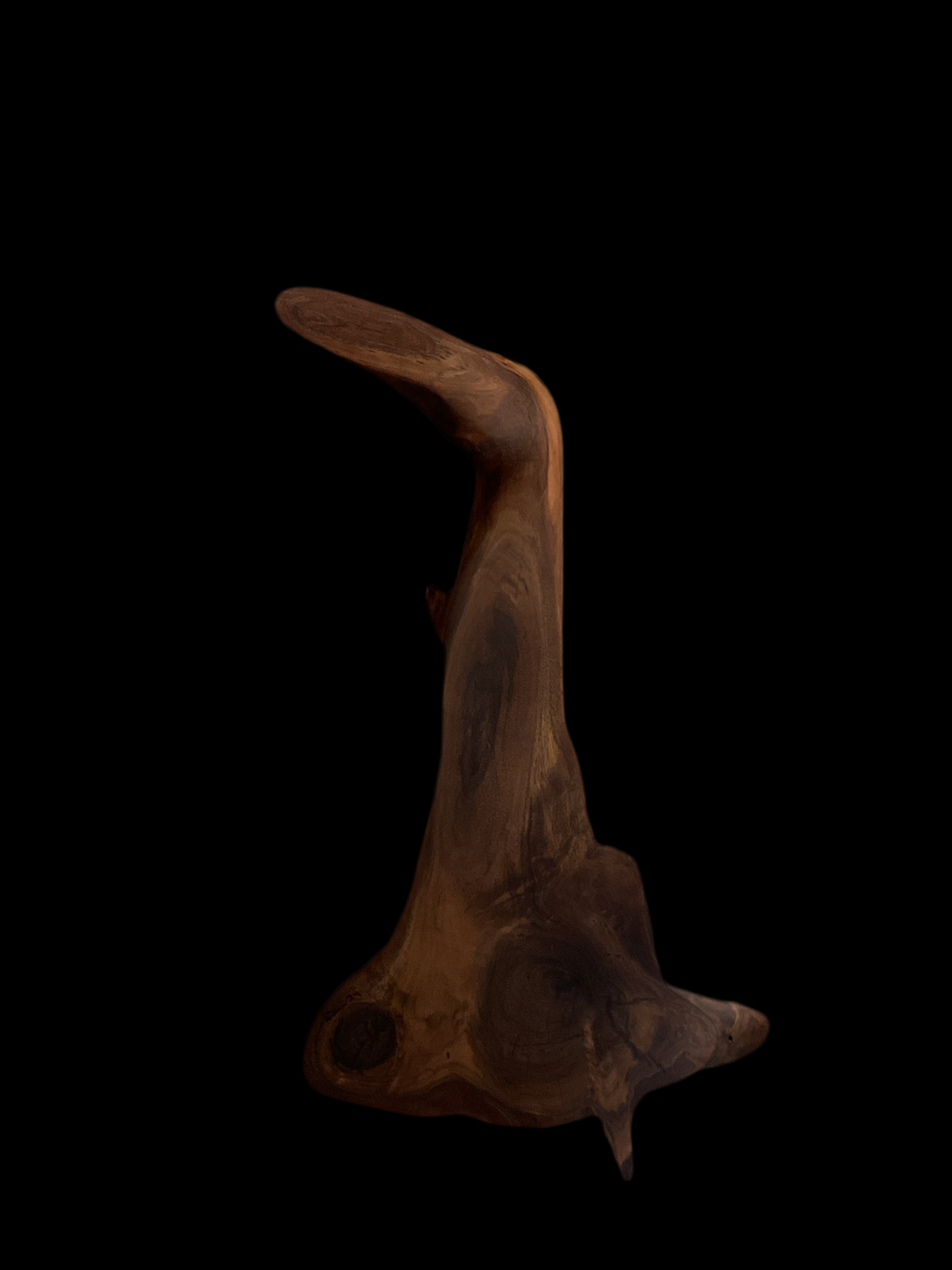 A one-of-a-kind black walnut board with a curved edge and a rough, textured surface.