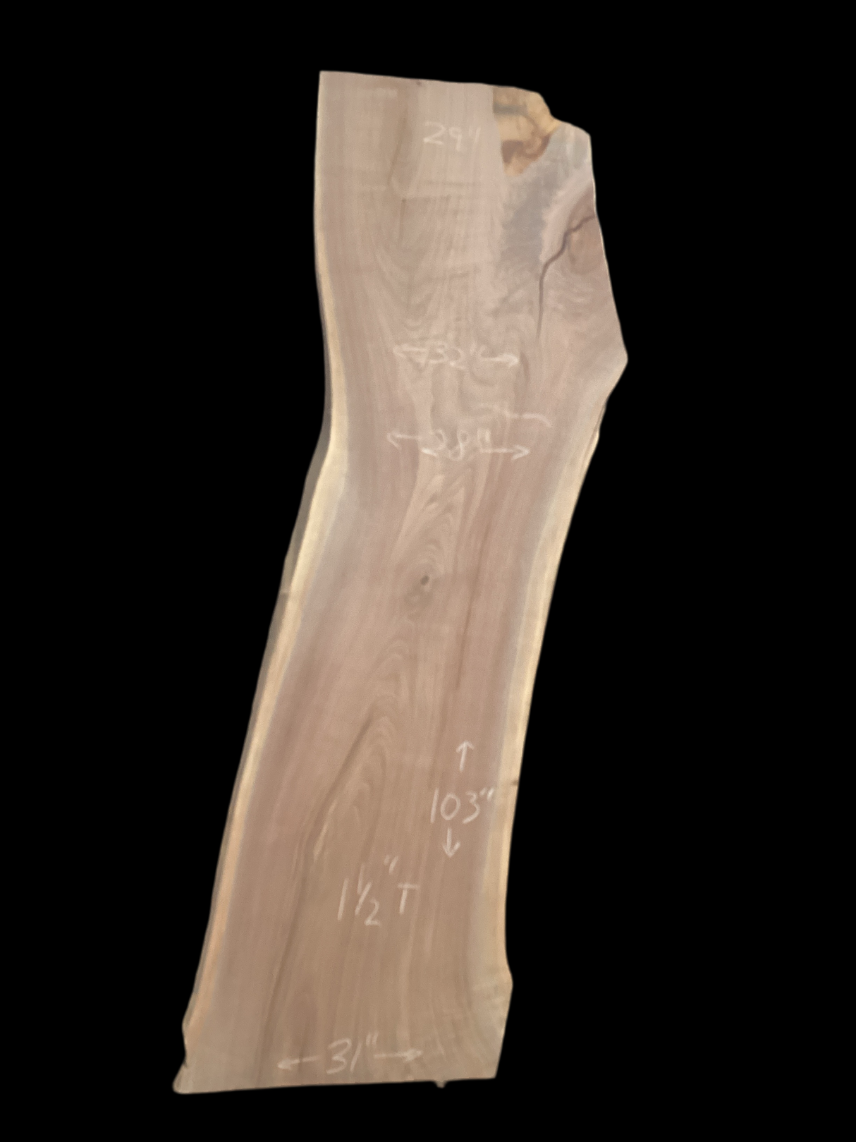 A long walnut slab on a black background.
