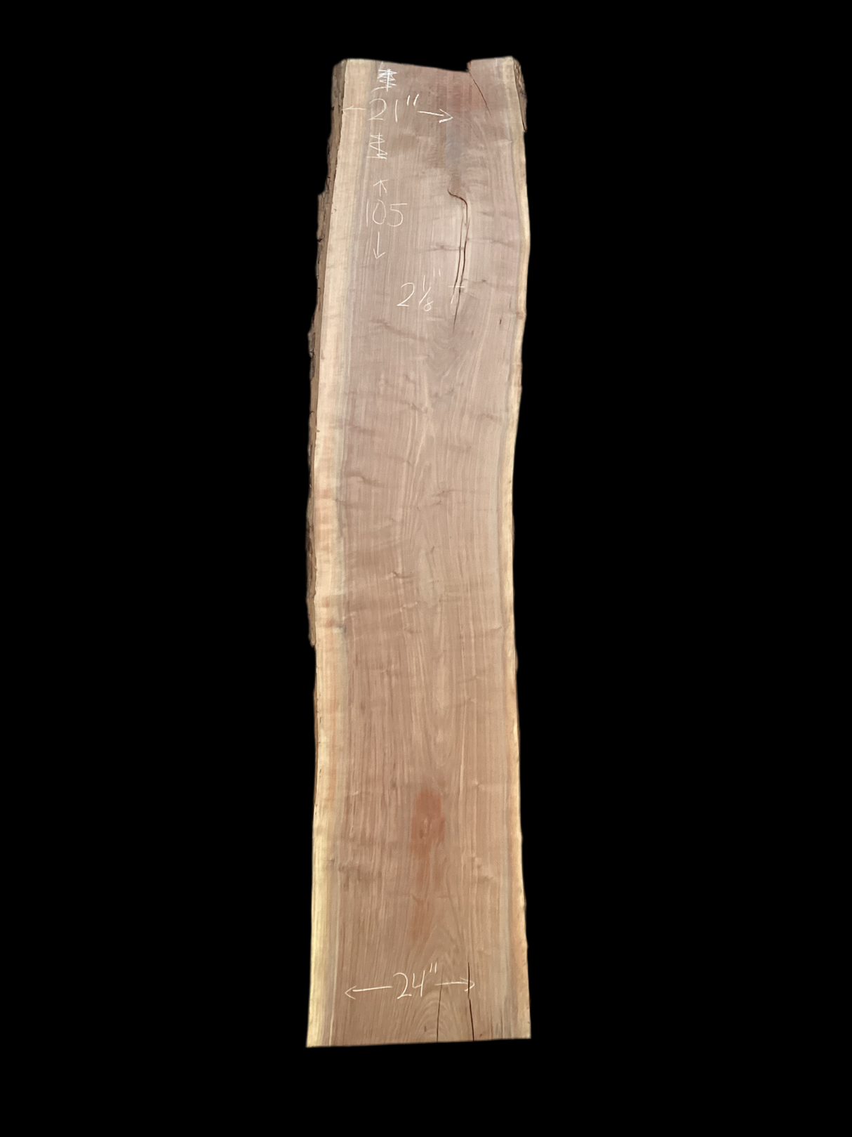 A long walnut wood slab on a black background.