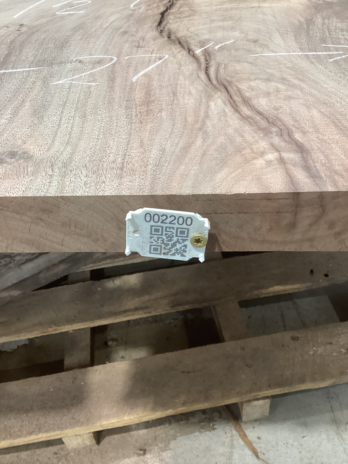 A walnut slab with unique lightning bolt patterns, with an attached tag displaying a QR code and number.