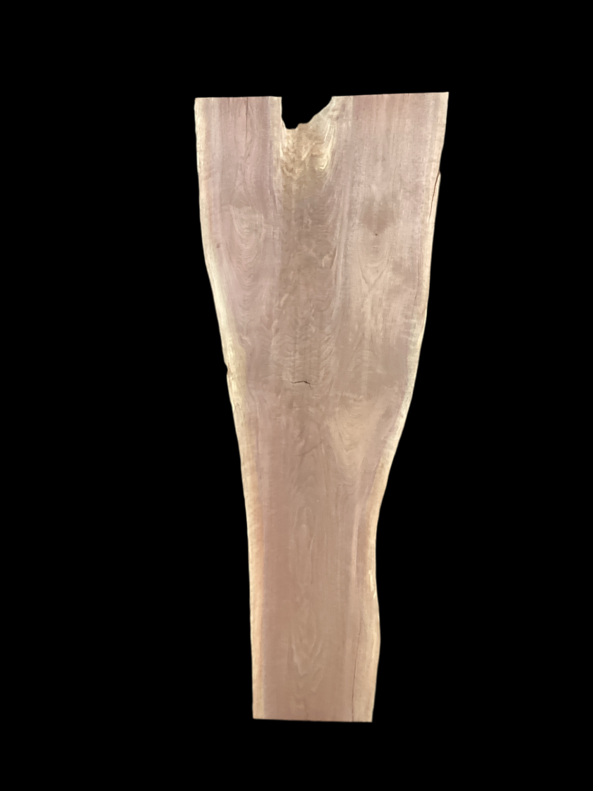 A long walnut slab, wider on one end than the other and on a black background.