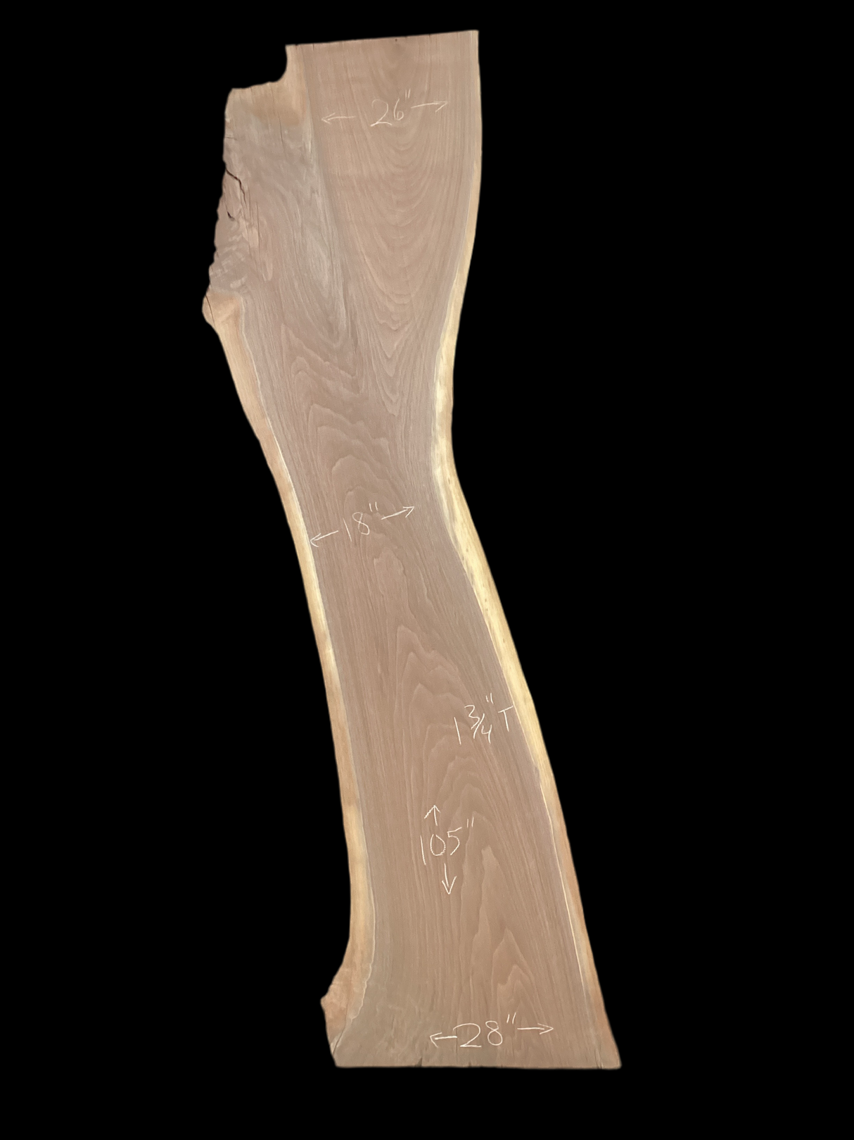 A long walnut slab on a black background.
