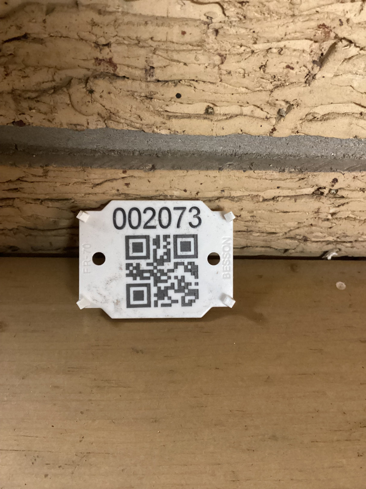 QR code with the sku 2073 against a brick wall.