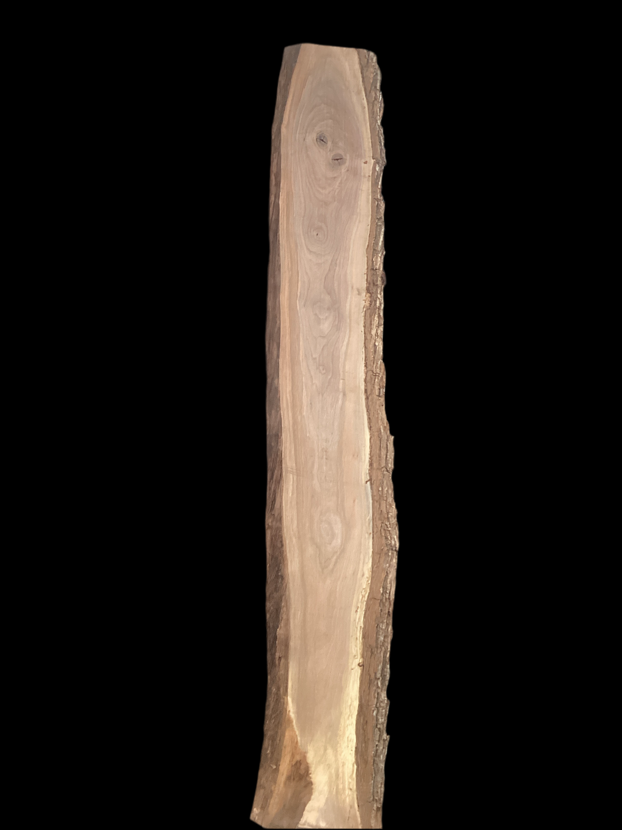 Large walnut wood slab with a black background.