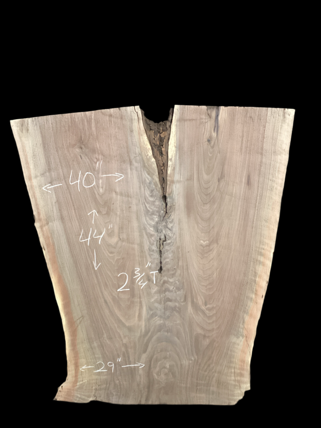 An irregularly shaped walnut slab with a distinctive striped figure pattern on a black background.