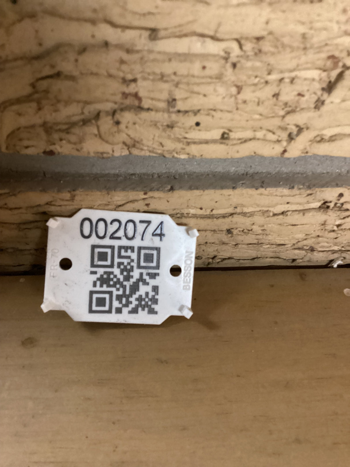 QR code with the sku 2074 positioned against a brick wall.