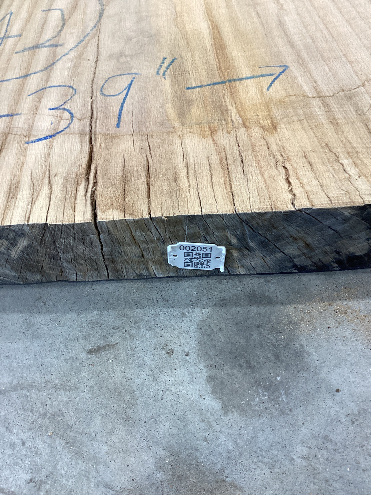 QR label attached to the edge of the red wood slab.