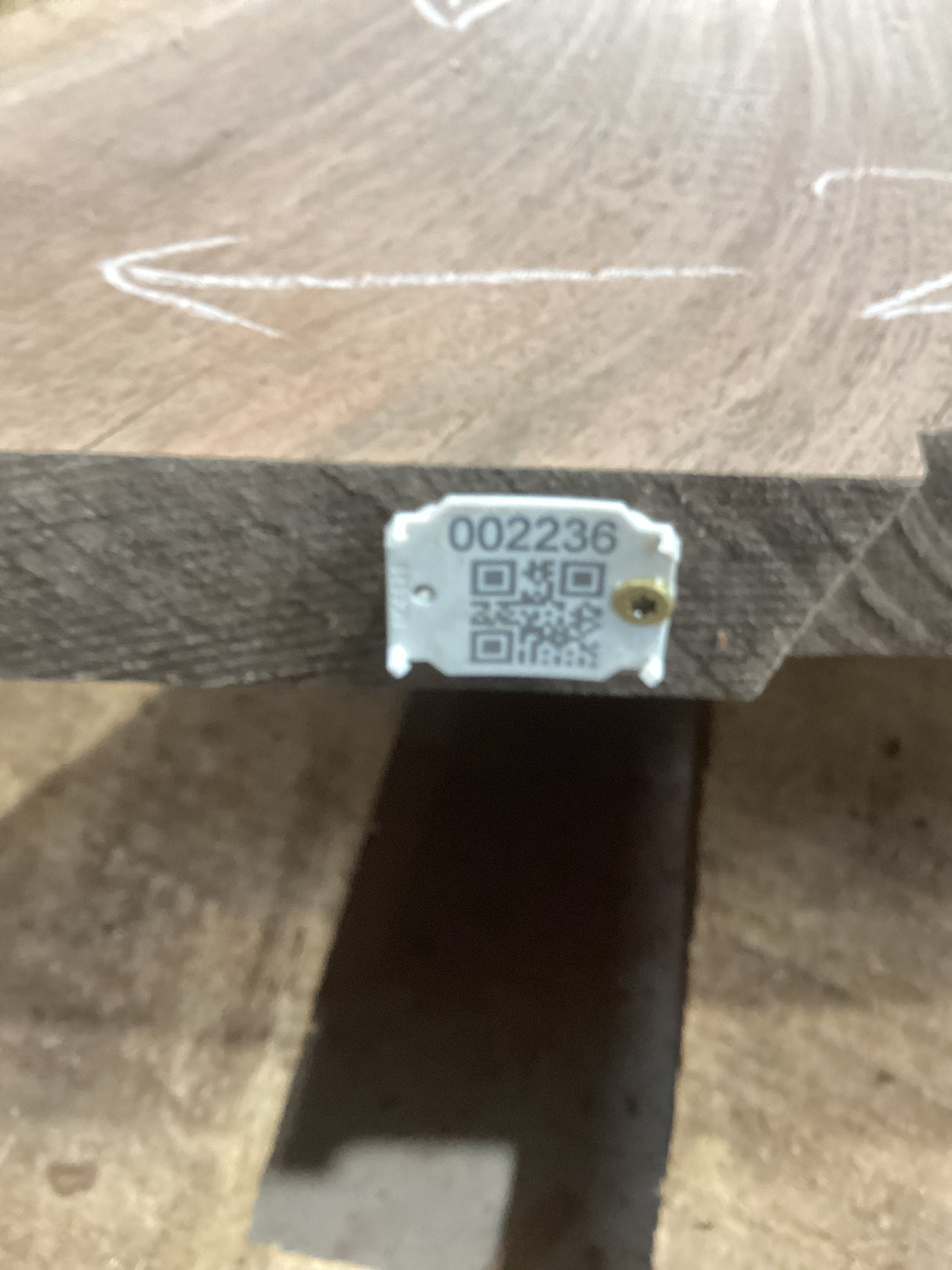 A walnut slab with a visible QR label attached to the edge.