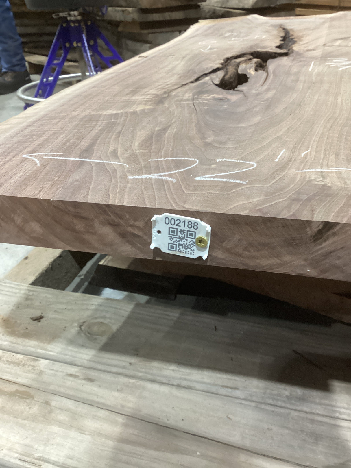 A walnut wood slab with a distinctive ingrown bark void, marked with identification tags.