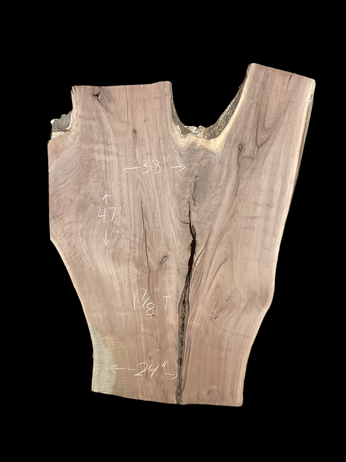An irregularly shaped walnut slab with a distinctive striped figure pattern on a black background.