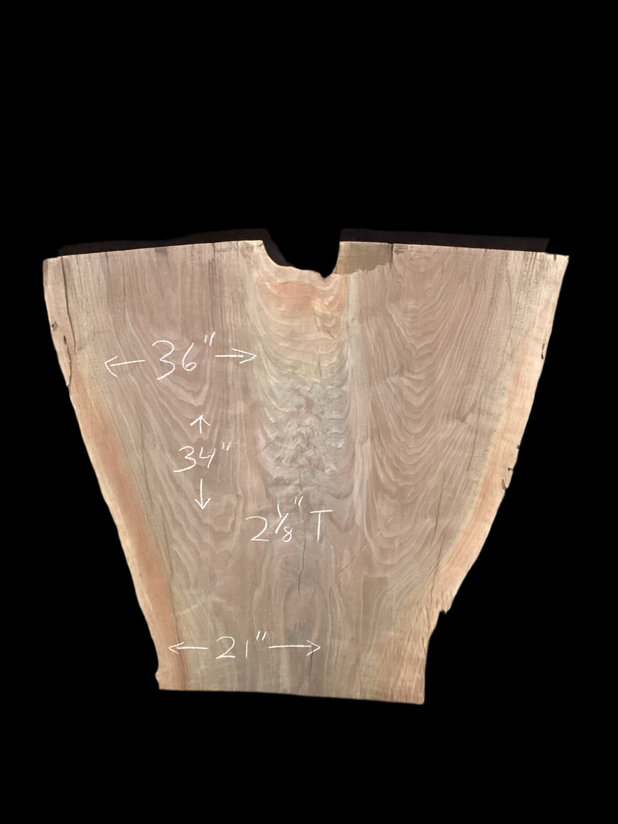 An irregularly shaped walnut slab with a distinctive striped figure pattern on a black background.