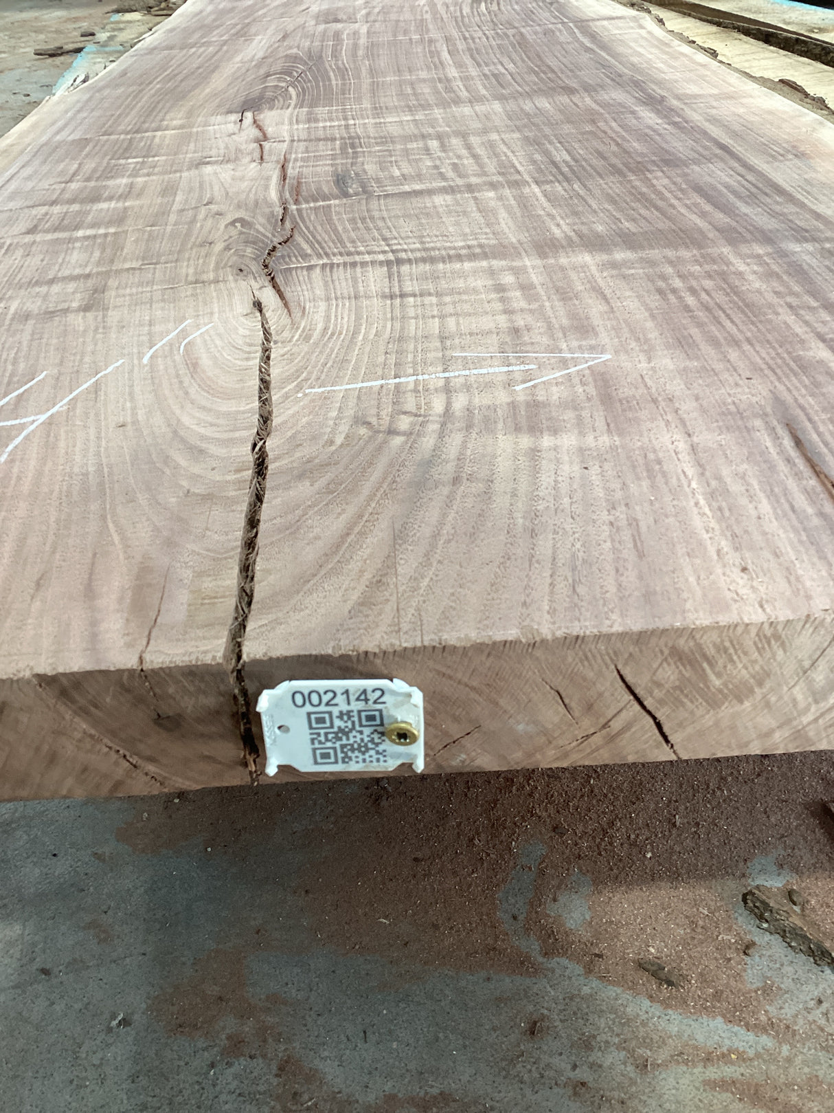 A walnut slab with visible wood grain and a visible QR label attached to the edge.