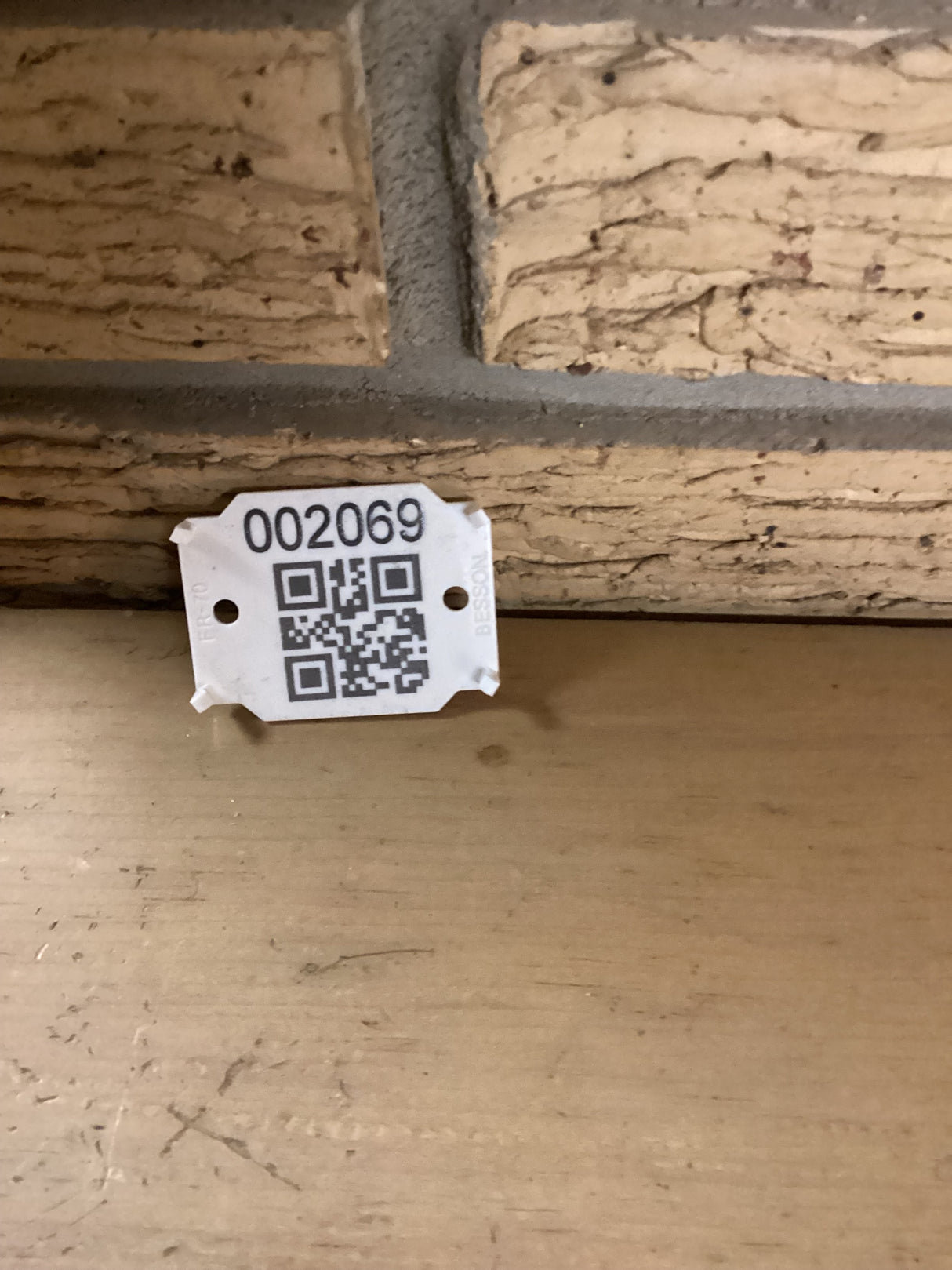 QR code with the sku 2069 against a brick wall.