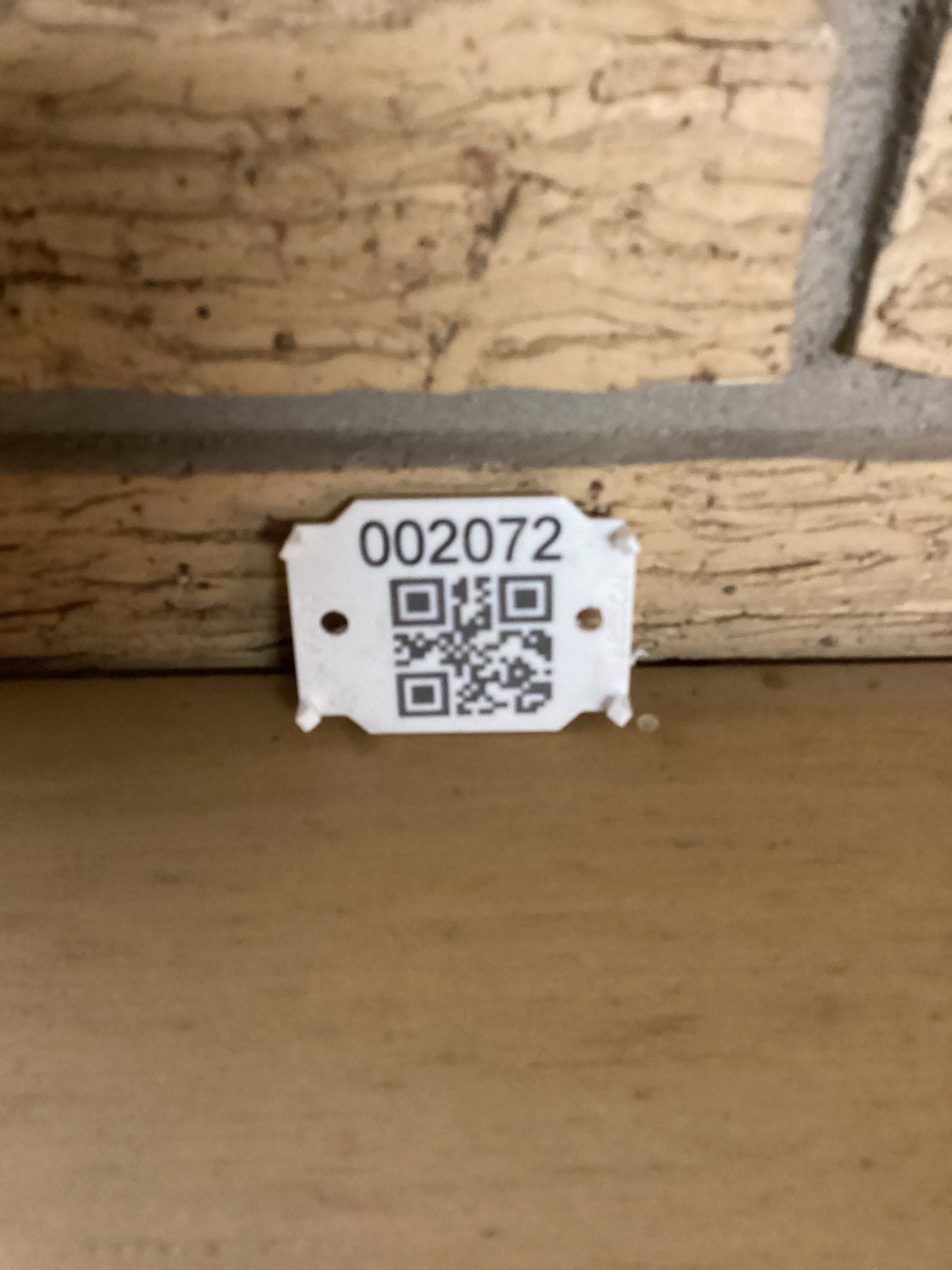 QR code with the sku 2072 against a brick wall.