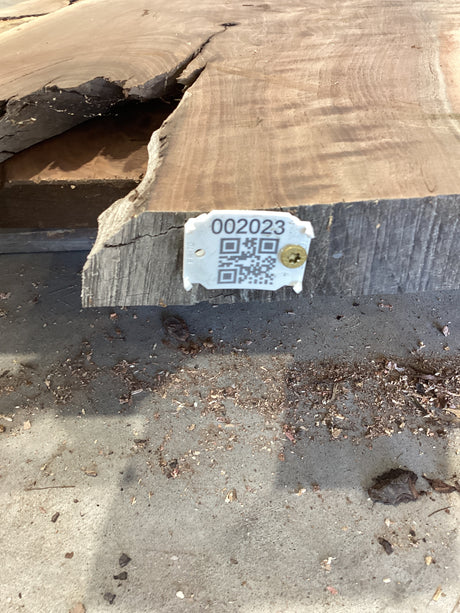 QR label attached to the edge of a walnut wood slab.