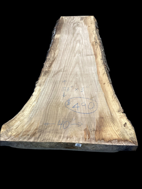 A beige-colored, solid-wood red oak slab with marked dimensions on it, indicating its size and shape.