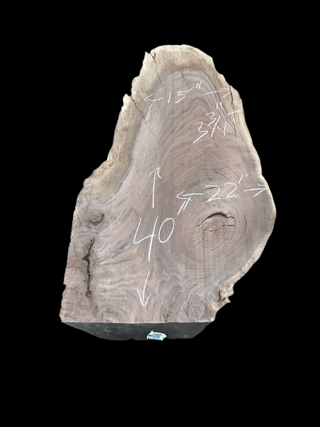 Irregular shaped walnut slab with a black background.