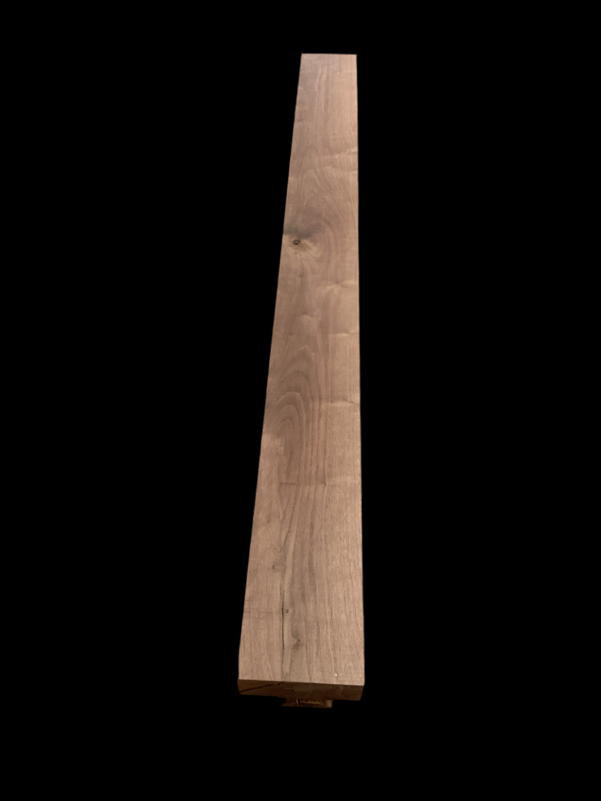 A walnut fireplace mantle with a natural finish, displaying the grain and color of the walnut wood.
