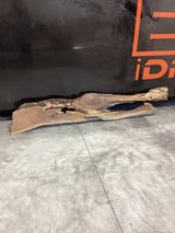 A walnut wood slab with a natural grain and unique river design, positioned on a gray floor against a black background with orange text.