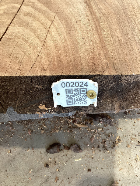 QR label attached to the edge of a walnut wood slab.