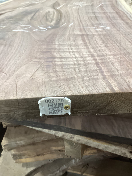 A walnut wood slab with a visible wood grain pattern and a QR tag attached to it.