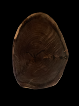 A round walnut charcuterie board with visible cracks and a darker center, surrounded by a lighter walnut border.
