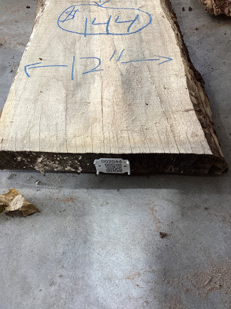 A Silver Maple wood slab edge with QR ode attached.
