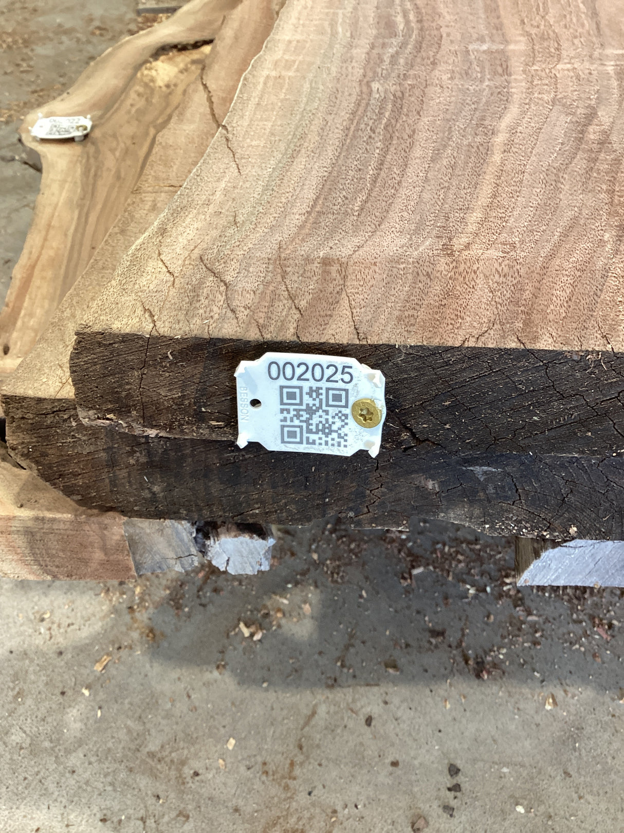 QR label attached to the edge of a walnut slab.
