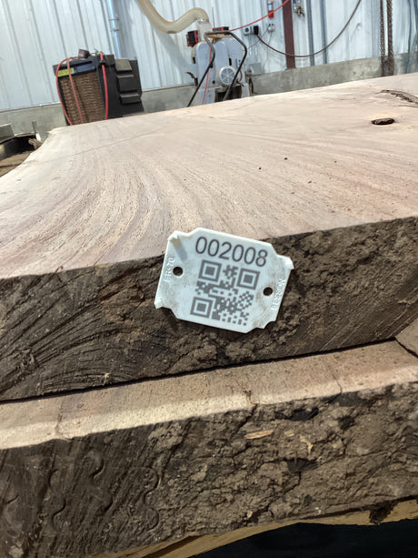 QR label attached to the edge of a walnut wood slab.