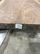 A walnut slab with a QR label in the lower right corner, displaying the wood's natural color and grain patterns.