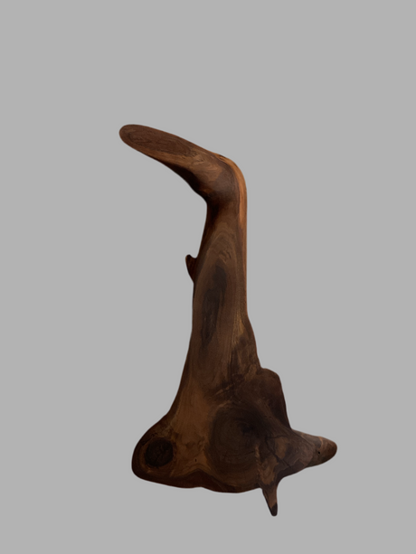 A one-of-a-kind black walnut board with a curved edge and a rough, textured surface.