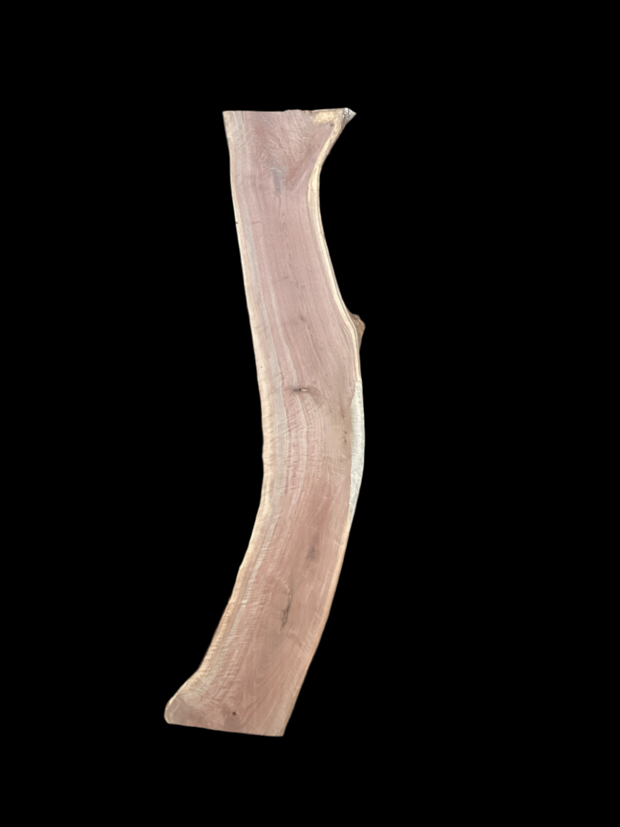 An irregularly shaped walnut slab with a black background.