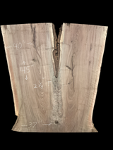 An irregularly shaped walnut slab with a distinctive striped figure pattern on a black background.