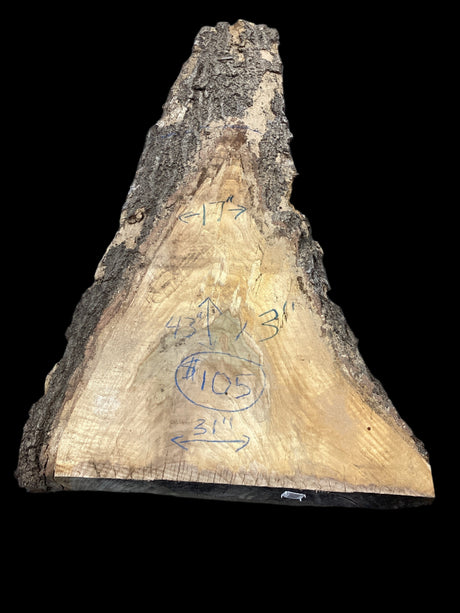 A rough, unpolished red oak wood slab with visible growth rings and measurement markings, on a dark background.