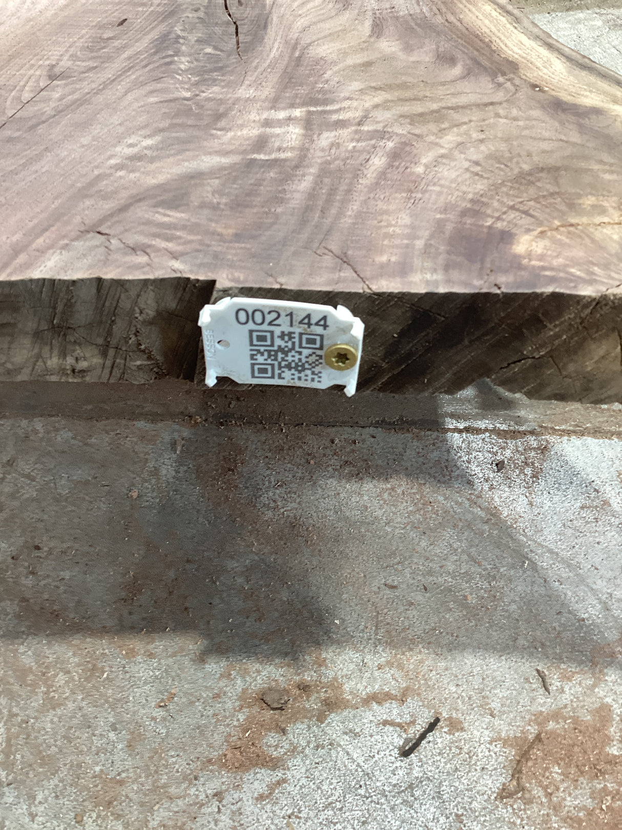 A walnut slab with a visible grain pattern, tagged with a QR label.