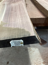 A walnut slab with a large split, featuring a QR tag with a barcode and measurements.