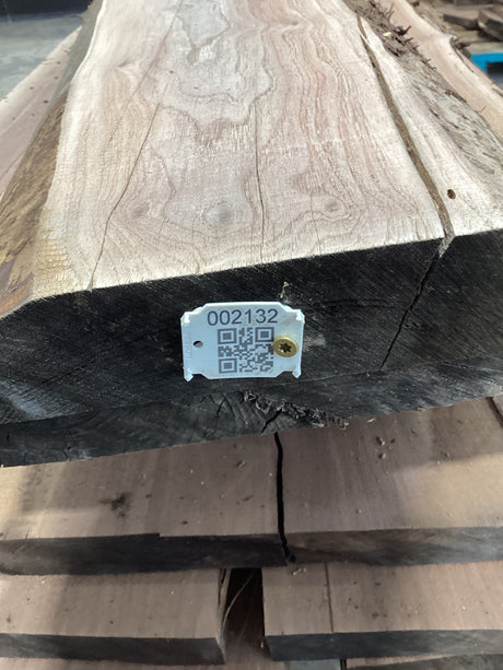 A walnut wood slab with a visible QR label stacked on wood.