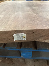 A walnut slab with a distinctive figure, featuring a QR code on a white label attached to the edge.