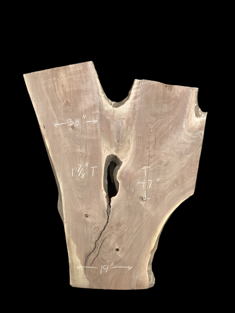 An irregularly shaped walnut slab with a distinctive striped figure pattern on a black background.