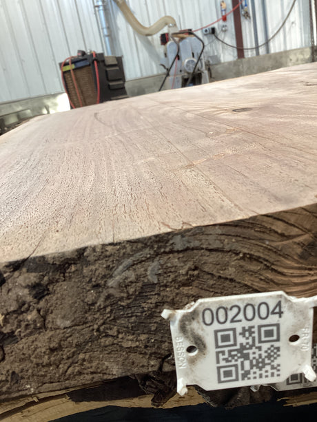 QR label attached to the edge of a walnut wood slab.