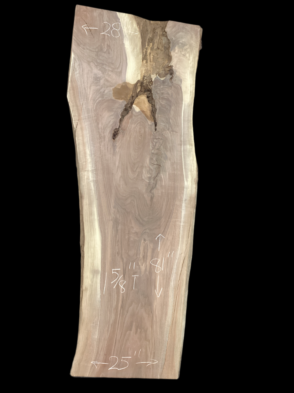 A long walnut slab, wider on one end than the other, and on a black background. 