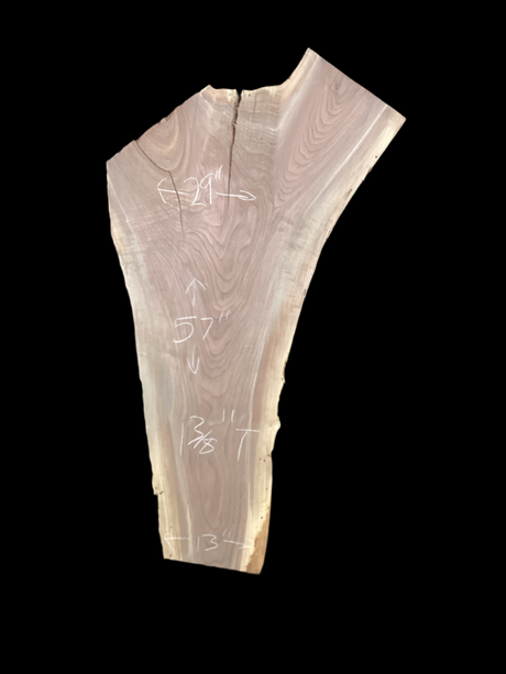 A short, irregular shaped walnut slab with a black background.