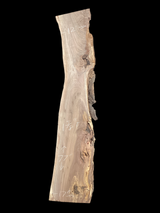 A long walnut slab with a black background. 