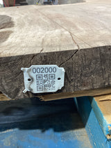 QR label attached to the edge of a walnut wood slab.