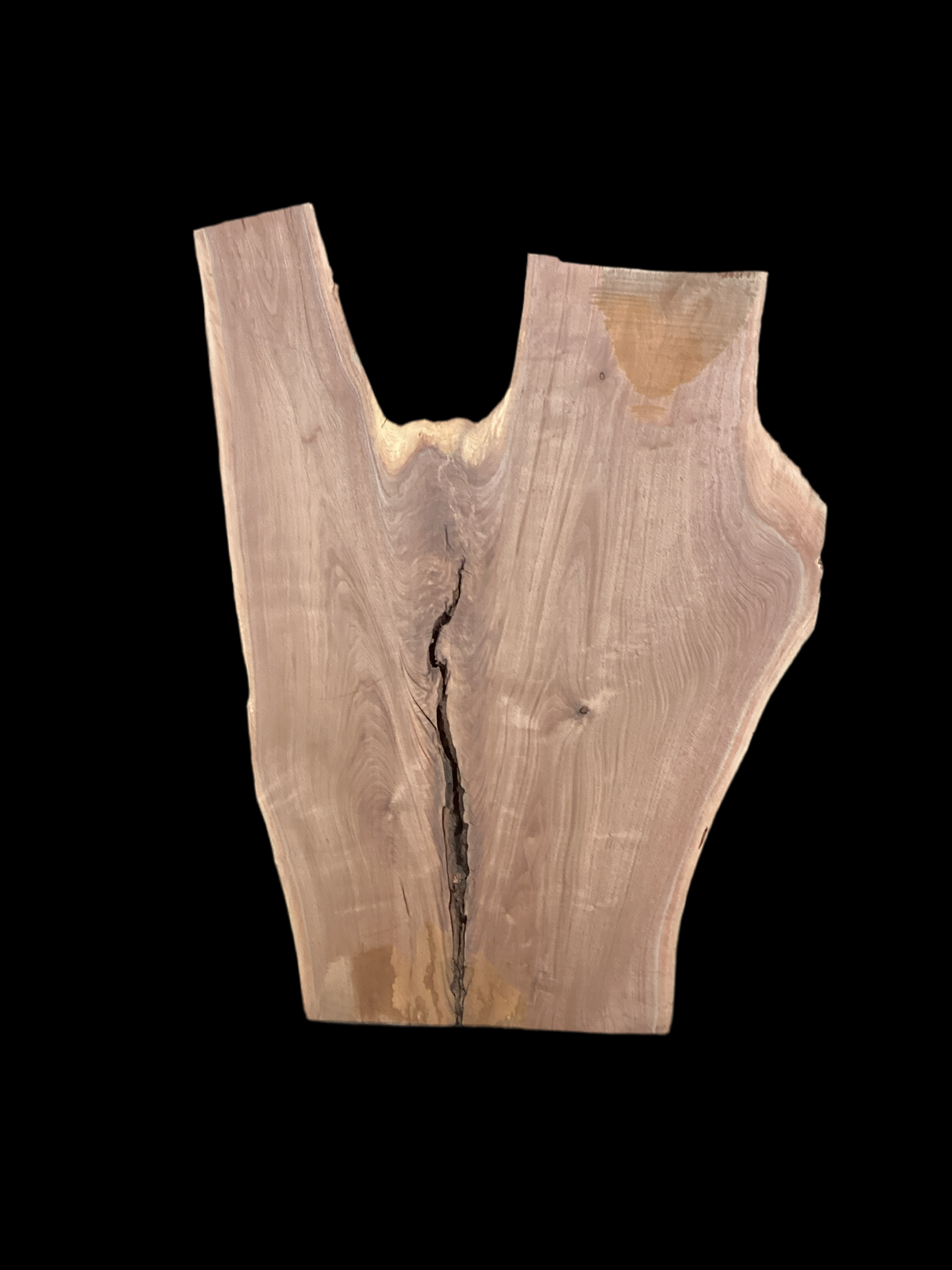 An irregularly shaped walnut slab with a distinctive striped figure pattern on a black background.